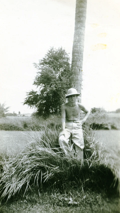 an old pograph of a  standing next to a palm tree