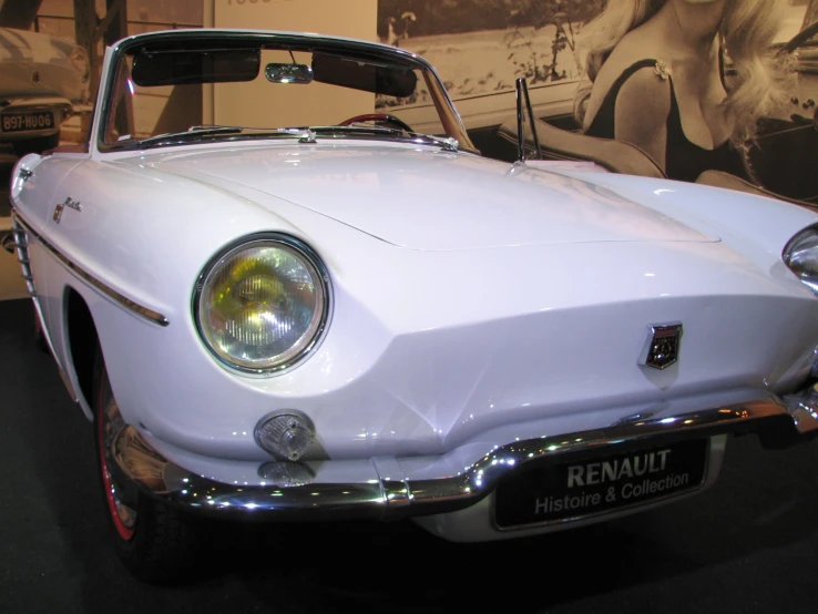 white car with hood up sitting on display