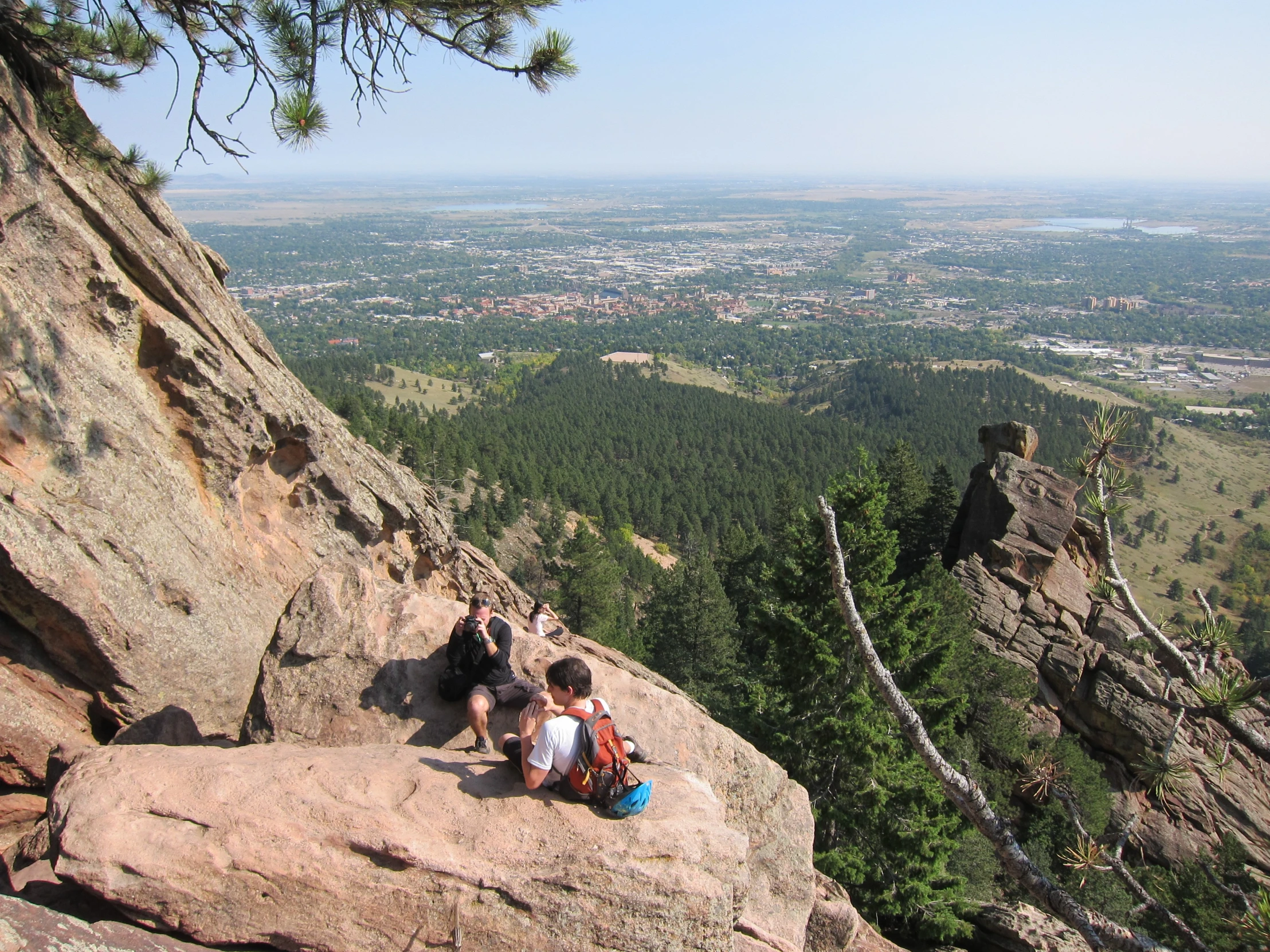 a couple of young men climbing up the side of a mountain