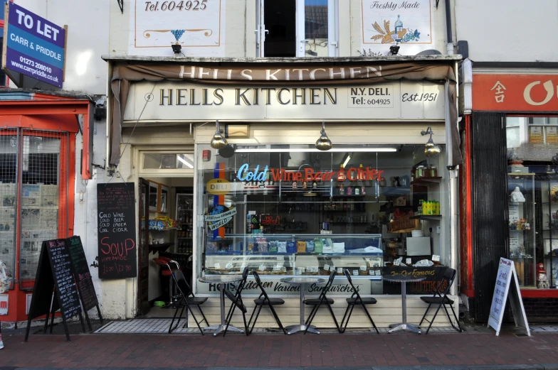 a store front with tables outside in front of it