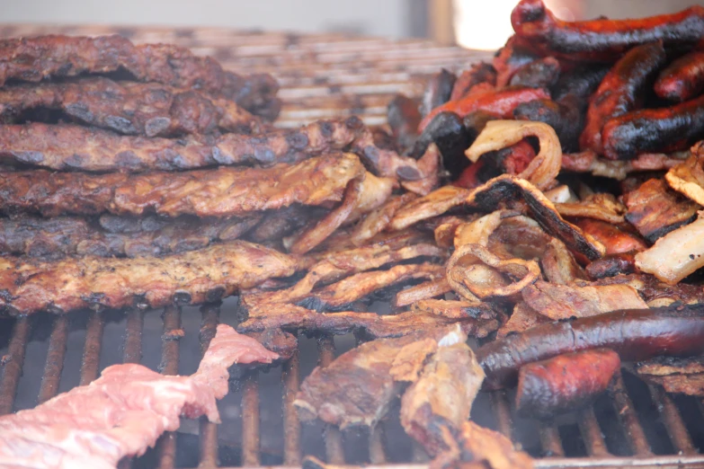 various types of food cooking on a grill