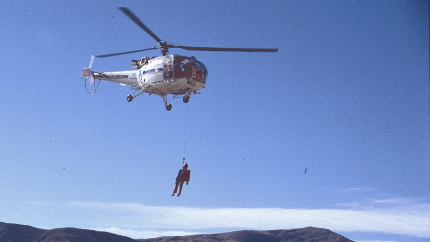 two workers roped off from the helicopter and unloading it