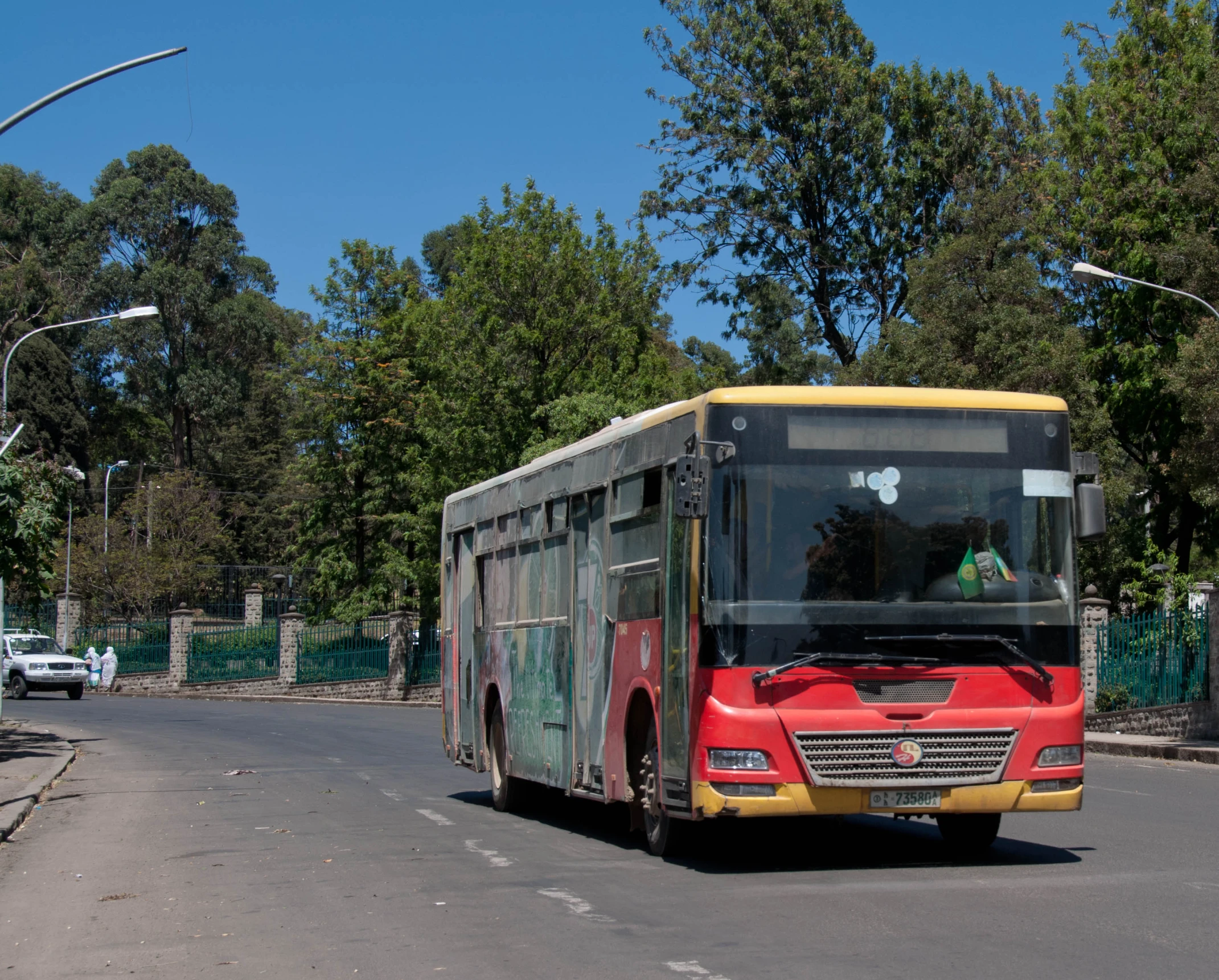 a bus travelling down the road near trees