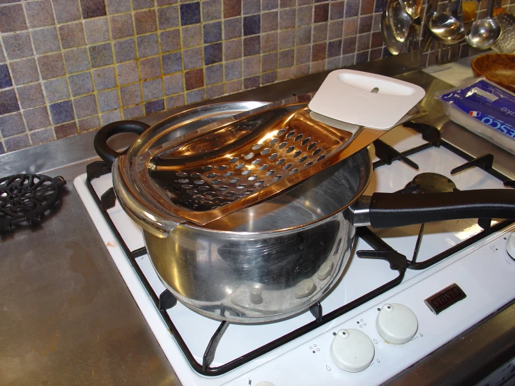 a cooking pot and a ladle are on the stove