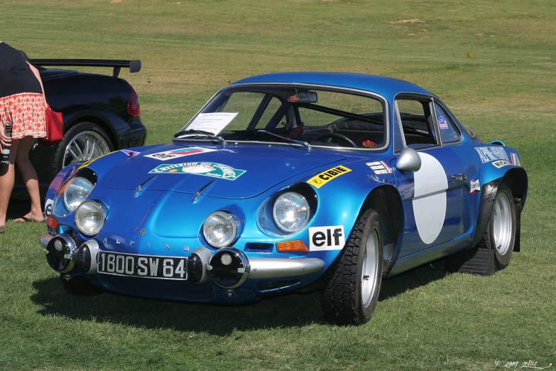 a vintage race car with a numberplate sitting in grass
