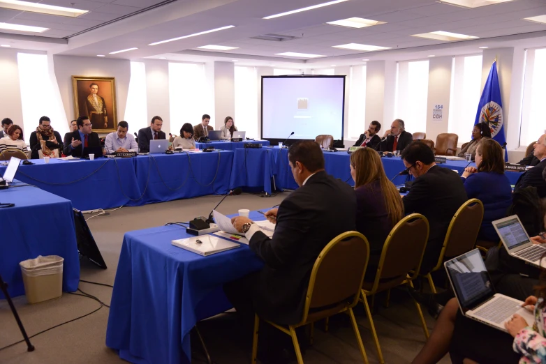 several people sitting around a table at an empty conference