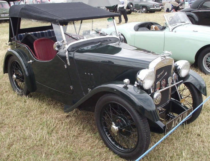 an antique car is parked in the grass