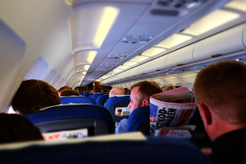 many people are sitting inside a plane with their cup