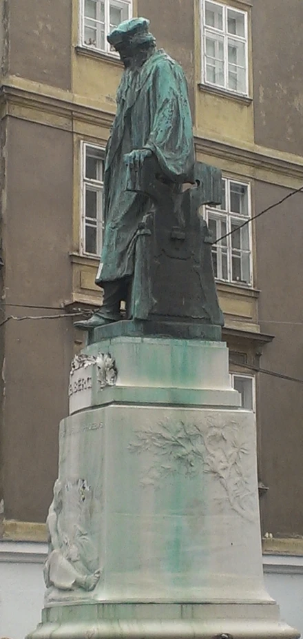 statue of a man wearing a hat with a cane