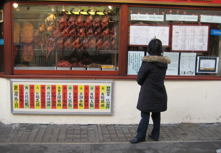 a person standing in front of a food store