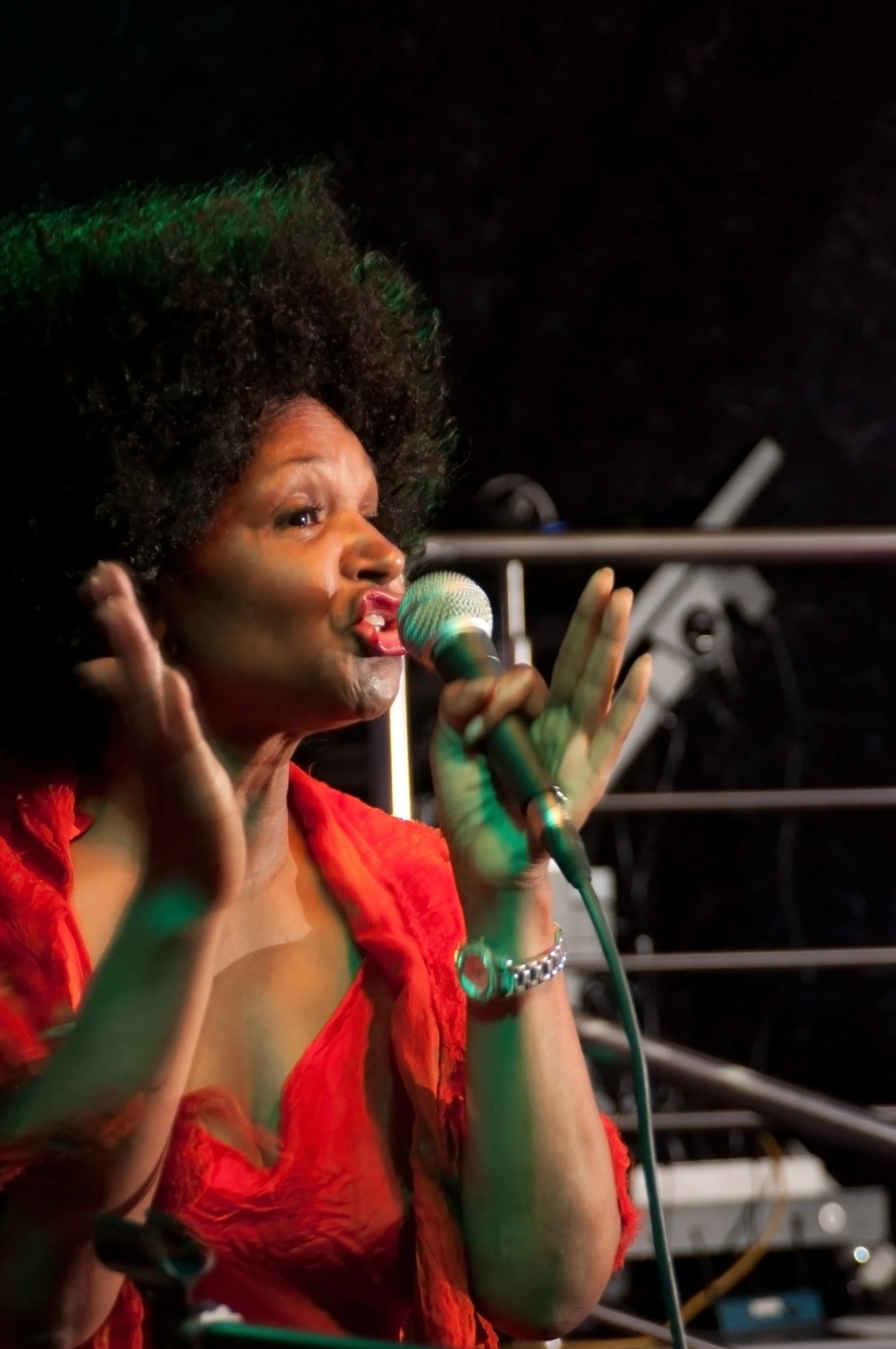 a woman wearing an orange dress and holding a microphone