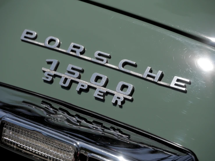 the front view of a vintage porsche emblem on a green car