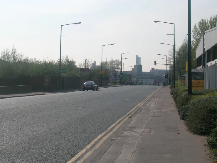 an empty road lined with traffic lights and tall buildings