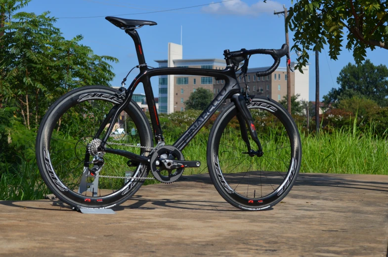 a bike with wheels parked in front of a building