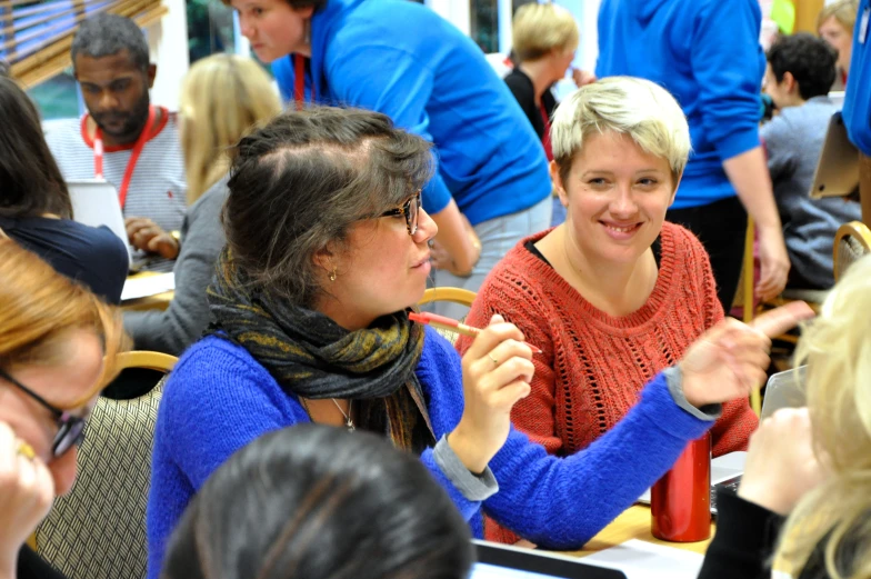 three women seated next to each other smiling