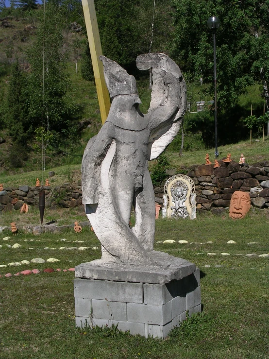 a statue in the middle of a grave on a green lawn