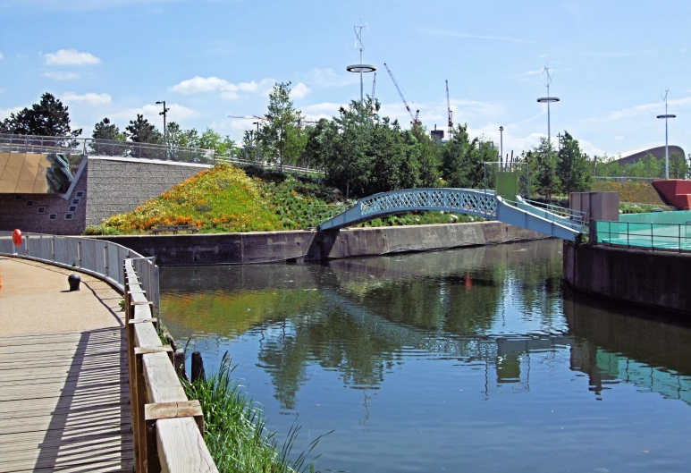 a pedestrian walkway going over water on the side of a canal