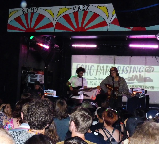 people at the concert looking on, and playing instruments