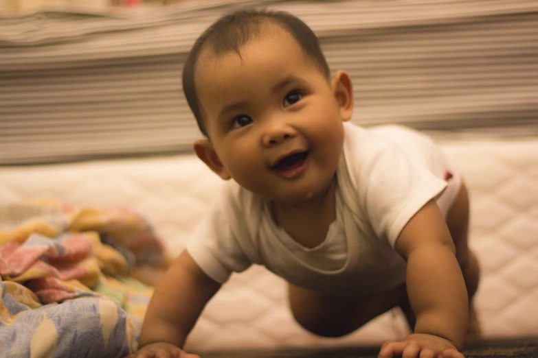 small baby on floor with hand in mouth