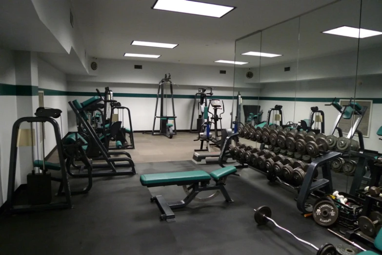 a gym filled with equipment and a mirror