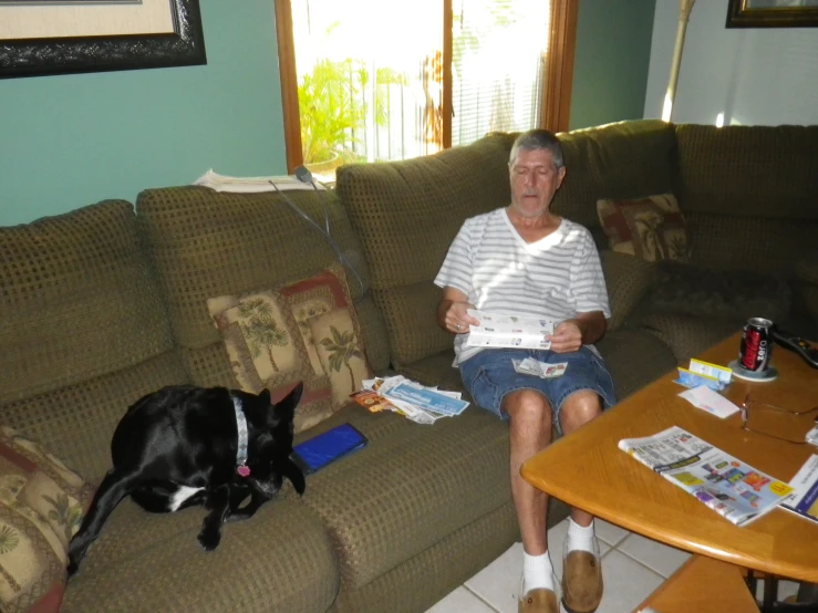 an older man is sitting in front of a dog on the floor