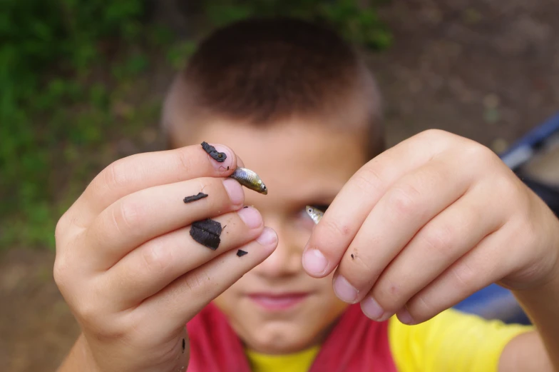 a boy in yellow shirt holding two different fingernail designs