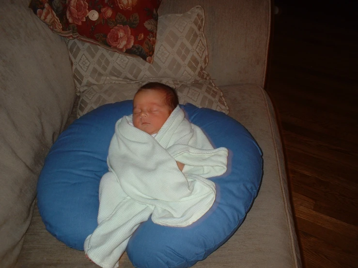 a small newborn child wrapped up in a blanket