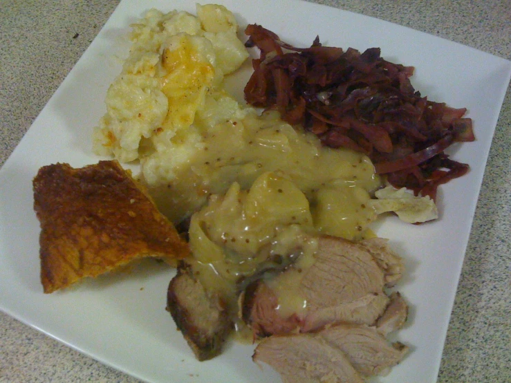meat, potatoes and sides sit on the plate