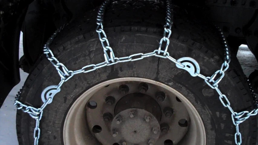 the tire chain has an oval shape and is attached to the wheel