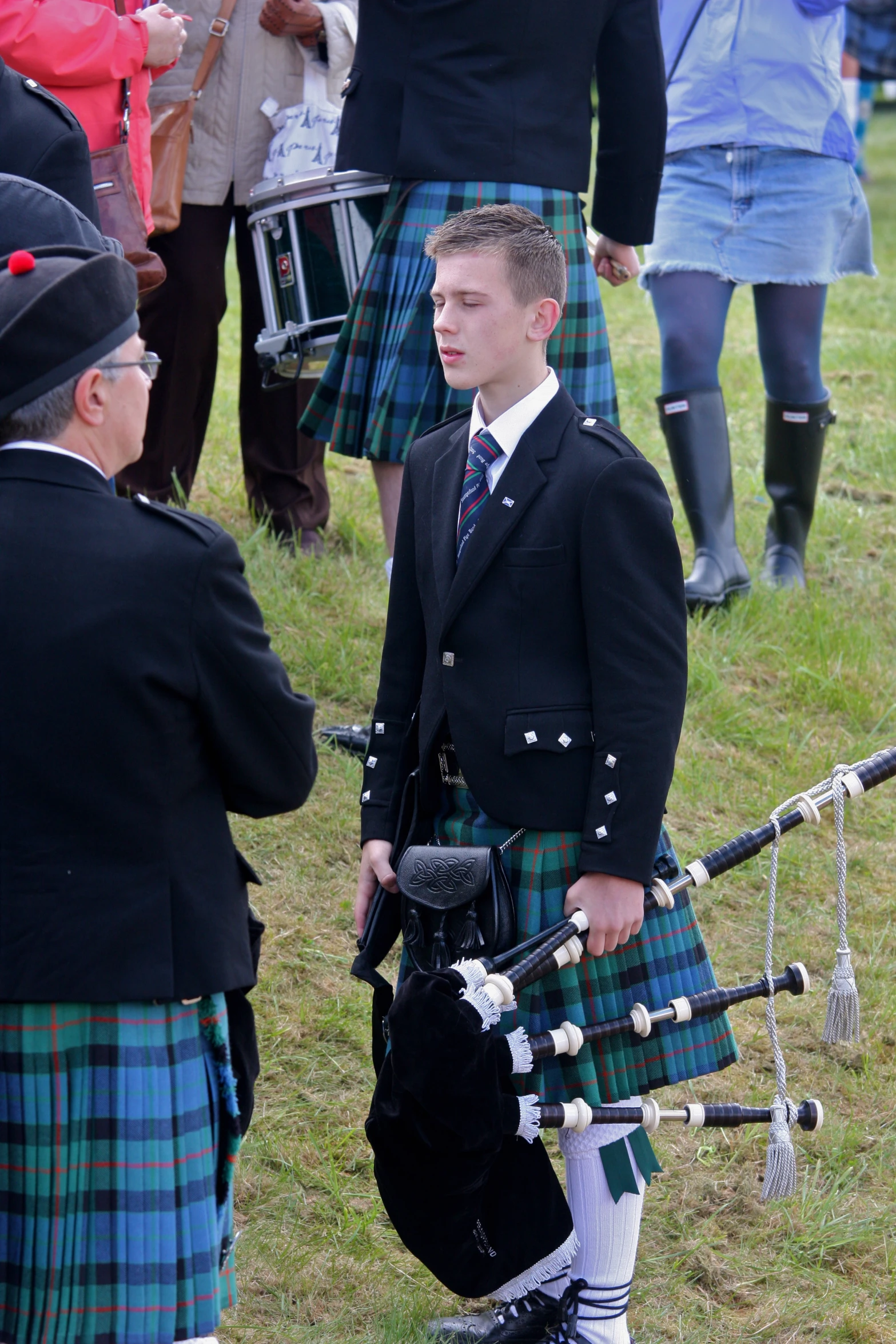 a man is playing a pipe band in the grass