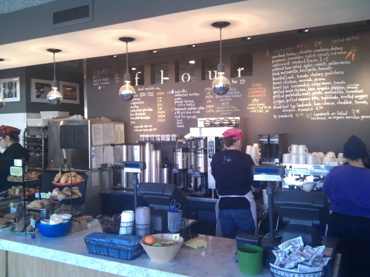 a coffee shop with people writing on the wall and coffee machines