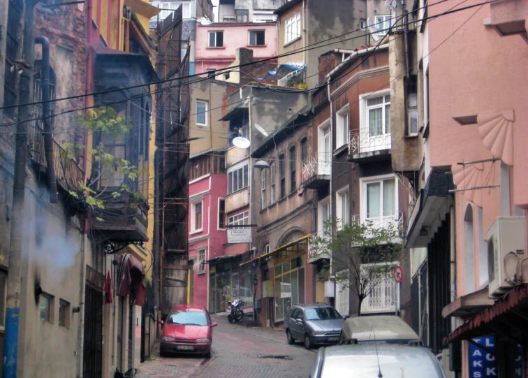 a street scene with cars parked next to a row of buildings