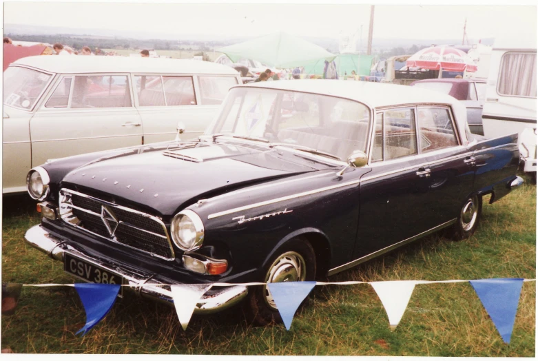 an old vintage black car parked in a grass field