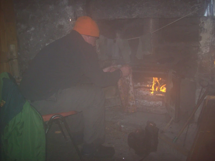 a man putting soing into a stove with a brick oven