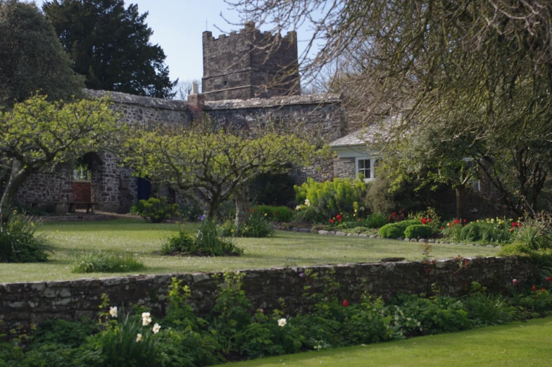 a stone house and garden with plants and trees