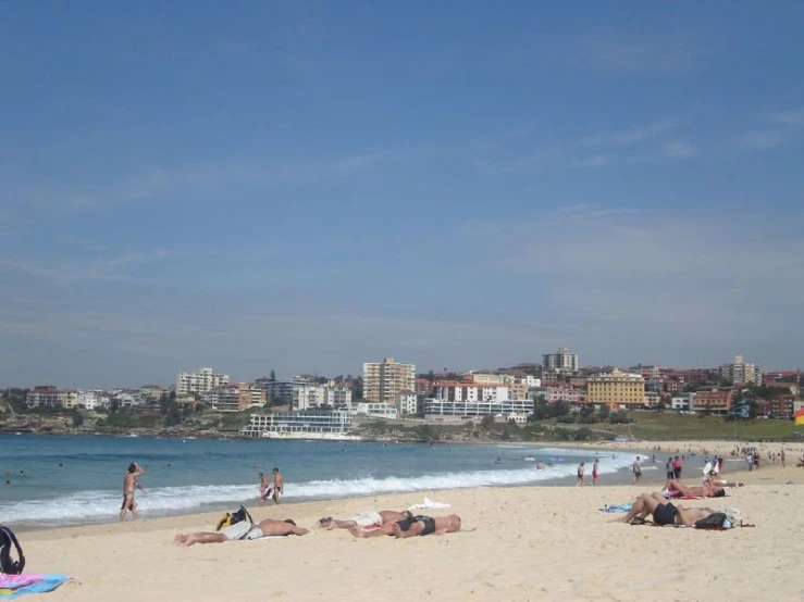 a busy beach has a kite flying over it