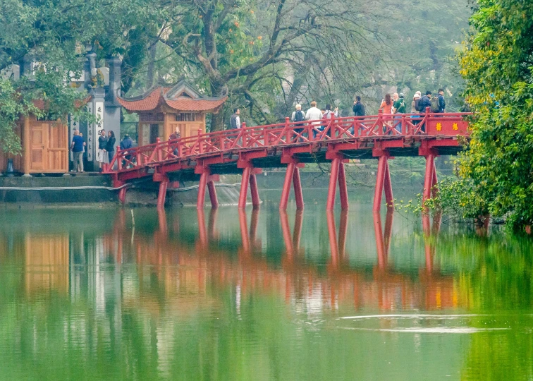 a long red bridge spanning over a river