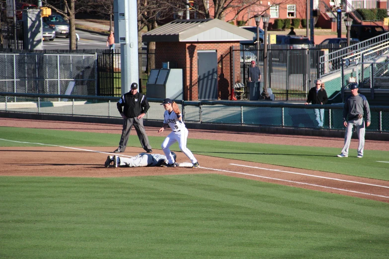 a baseball player sliding into home plate on a sunny day