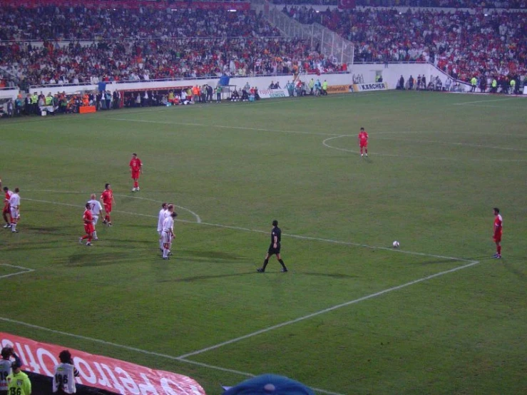 two teams are playing a soccer game in a stadium