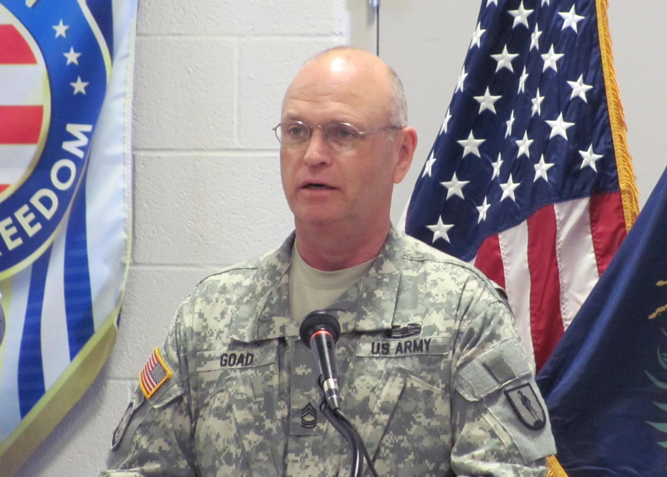 a man in a military uniform speaking into microphone