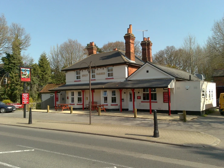 a small white building sits on a corner with chimneys