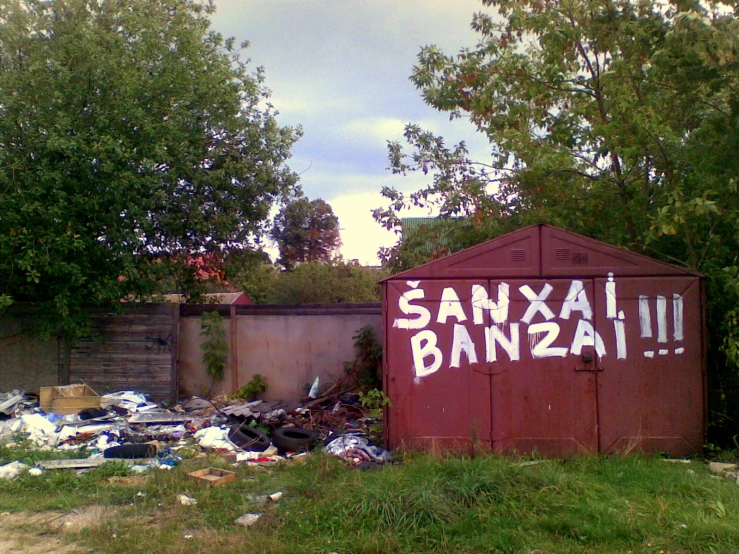 graffiti is written on a storage shed in a junk yard