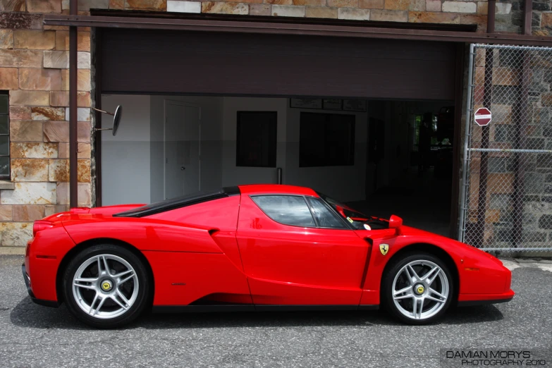 a red sports car sitting outside a garage