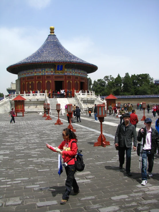 children standing around in an outdoor park with a pagoda building