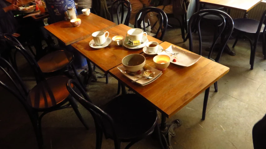 a table has coffee cups, tea pots and plates on it