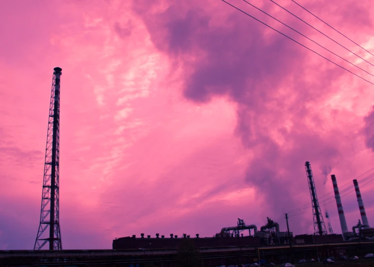 purple and red sky with smoke coming out the stacks