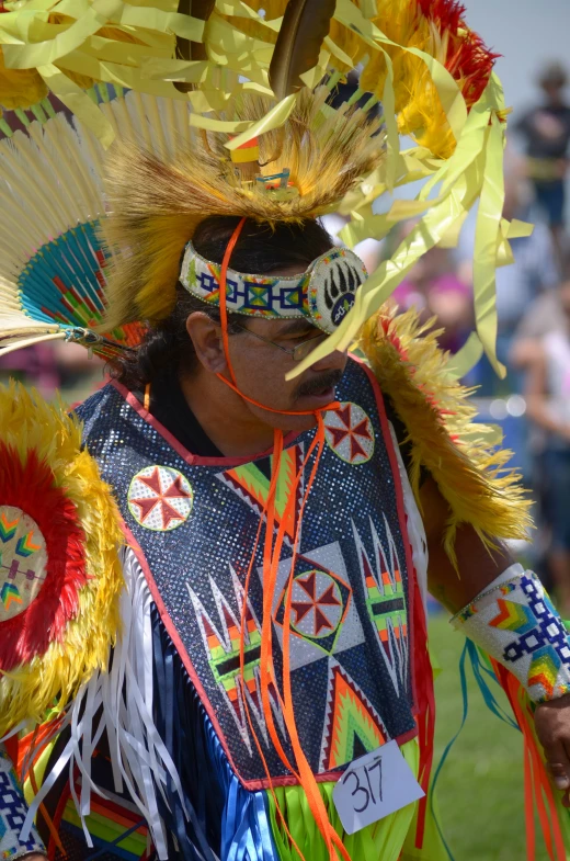 a person standing with a hat on their head and feathers on it