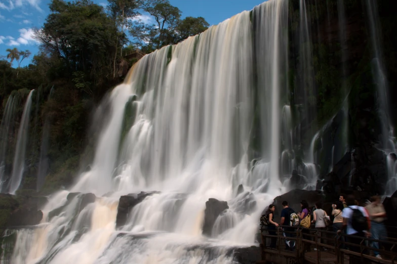 tourists standing on the edge of a waterfall