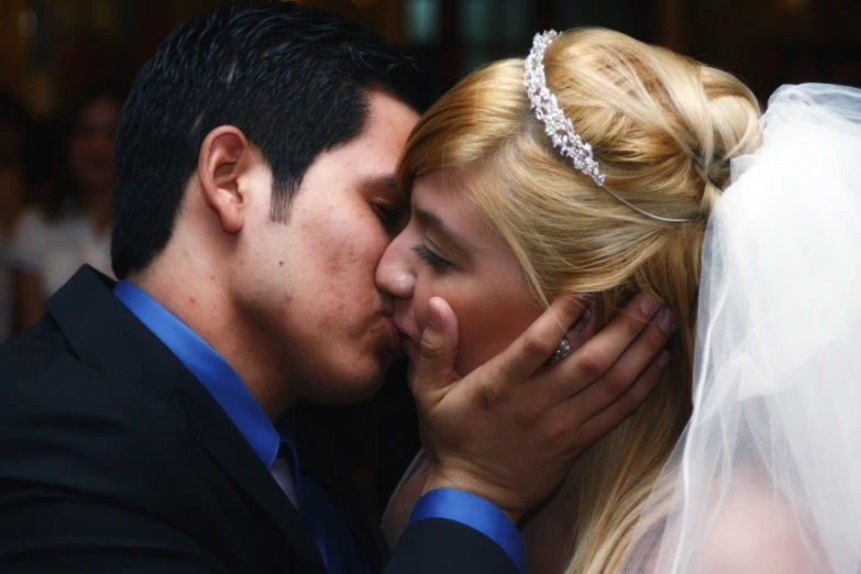 a bride and groom kissing in a wedding dress