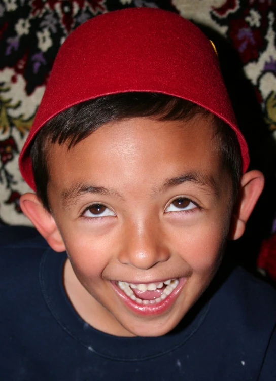 there is a boy smiling wearing a hat